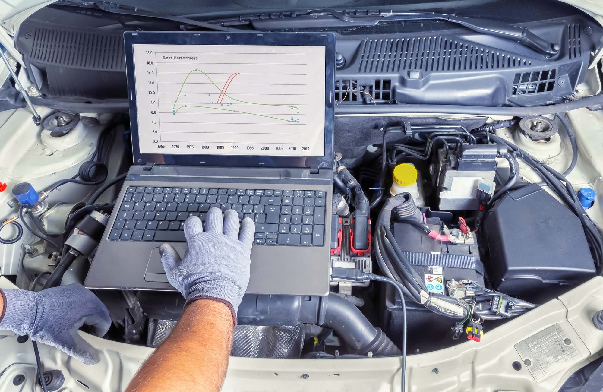 Diagnostic car computer. Professional car mechanic working in auto repair computer service